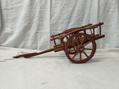 une charrette en bois à laquelle est fixée une roue en bois