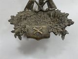a silver plate with a bird and a basket of flowers on it