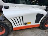 a white and orange forklift parked in front of a building
