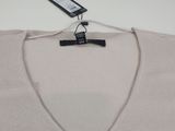 a close up of a sweater hanging on a hanger on a wall