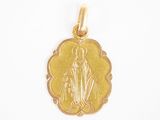 gros plan d'un pendentif en or sur fond blanc