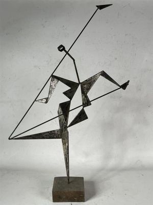 une photo d'une sculpture métallique représentant un homme tenant un cerf-volant