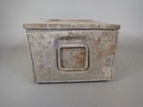 a small metal box with a handle on a table