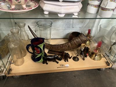 une étagère en verre sur laquelle sont disposés de nombreux objets variés