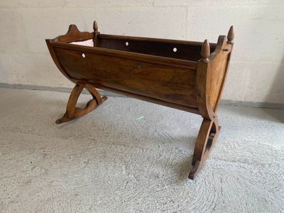 Berceau en noyer reposant sur un piètement en X à bascule. - Photo 1