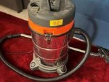 an orange and gray vacuum cleaner sitting on a red carpet