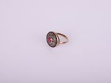 a close up of a ring with a red stone in it