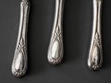 three silver spoons and a fork on a black surface