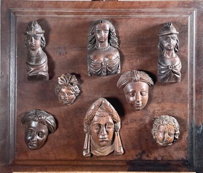 une plaque en bois sur laquelle figurent de nombreuses têtes différentes