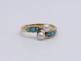 a close up of a gold ring with pearls and turquoise stones
