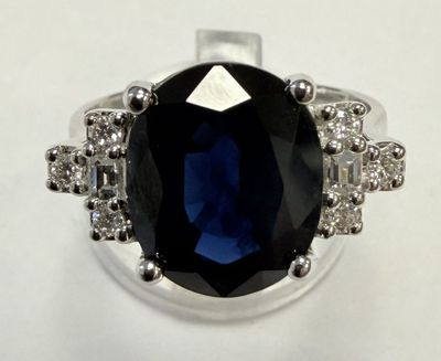 a picture of a ring with a large blue stone surrounded by small white diamonds