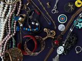 many different necklaces and bracelets laid out on a table