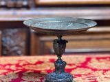 un petit bol en métal posé sur une nappe rouge