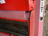 a red machine that is sitting in a warehouse