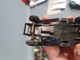 a person holding a model of a race car in their hand