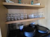 de nombreux verres et assiettes sur une étagère dans la cuisine