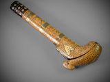 an old wooden pipe with a metal handle on a gray surface
