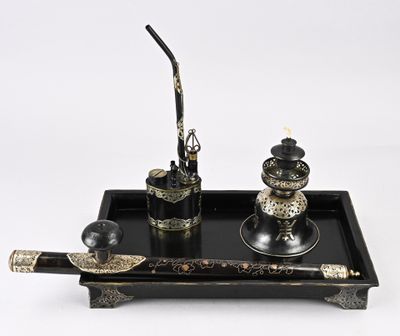 un plateau noir sur lequel se trouvent un stylo, un encrier et une plume