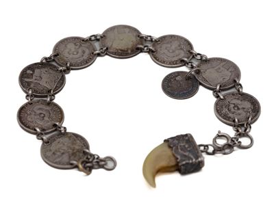 une image représentant un bracelet orné de pièces de monnaie et d'une dent
