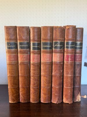 a set of five old books sitting on top of a wooden table