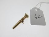 une petite clé en laiton et une étiquette posées sur une table