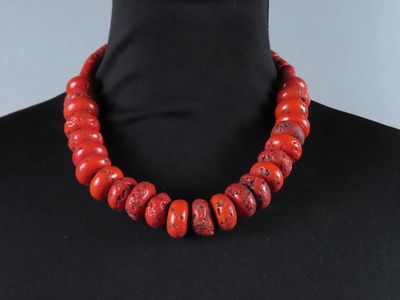 un collier de perles de corail rouge sur un mannequin, un mannequin, un mannequin, un mannequin, un mannequin, un mannequin, un mannequin, un mannequin