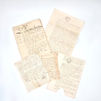 several old letters are sitting on top of each other on a white surface