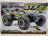 La boîte d'un monster truck miniature est posée sur la table.