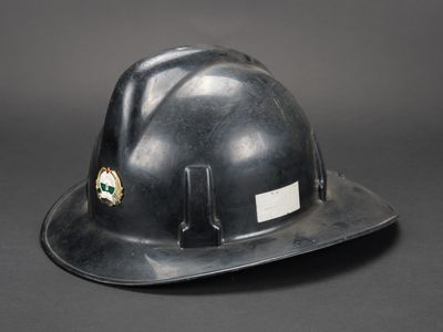 un casque de chantier orné d'un autocollant sur fond noir