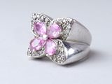silver ring with pink stones and clear crystals on a white background