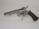 a silver revolver with a wooden handle on a white surface
