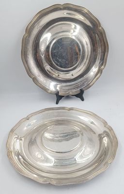 two silverplated dishes on stands on a white surface
