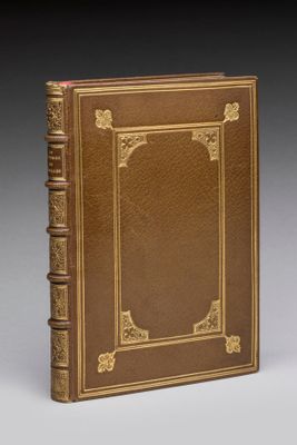 un livre en cuir marron avec des finitions dorées et une bordure dorée