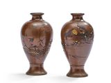 deux vases marron ornés de motifs, placés l'un à côté de l'autre