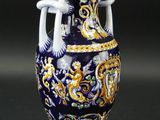 un vase bleu orné de motifs dorés et blancs