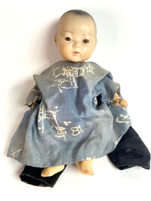 une image représentant une petite poupée vêtue d'une robe bleue et de chaussures noires