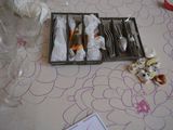 a tray with silverware on a table with a flower pattern