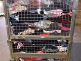 a cart with a lot of clothes on it in a warehouse