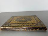 an old book sitting on top of a table next to a white wall