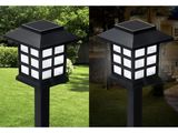 a couple of black and white lights sitting on top of a lush green field