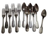 several forks and spoons are arranged in a row on a white surface