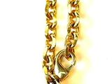 gold chain with a purse charm hanging from it ' s side