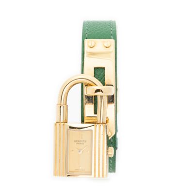 une image représentant une montre dorée et verte ornée d'un cadenas