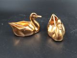 paire de figurines de cygnes plaquées or sur un fond noir
