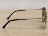 sunglasses on a wooden table with a white wall in the background
