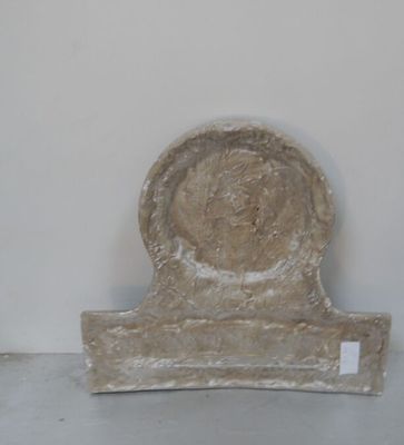 une sculpture en pierre représentant une tête posée sur un socle