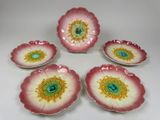 six assiettes en forme de fleur, roses et jaunes, avec un centre vert