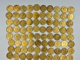 a pile of gold coins sitting on top of a white surface