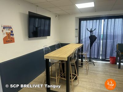 une photo d'une salle de réunion avec une télévision et une longue table