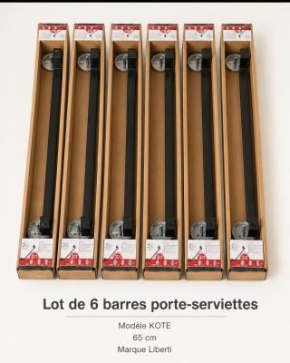 six boîtes de tiges noires dans un carton posé sur une surface blanche